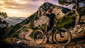 Homme déçu à côté de son VTT sur un sentier escarpé du Plantaurel, location VTT gâchée à cause du dénivelé